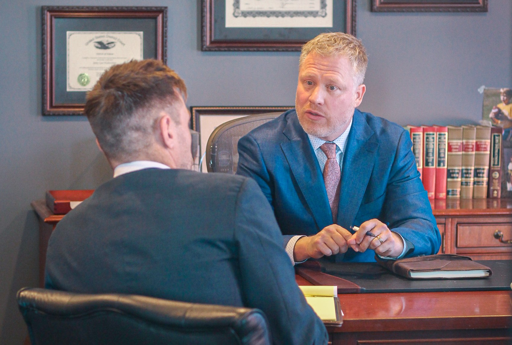 attorney Jerry and CJ sit at desk collaborating - insurance tactics in KS and MO personal injury claims
