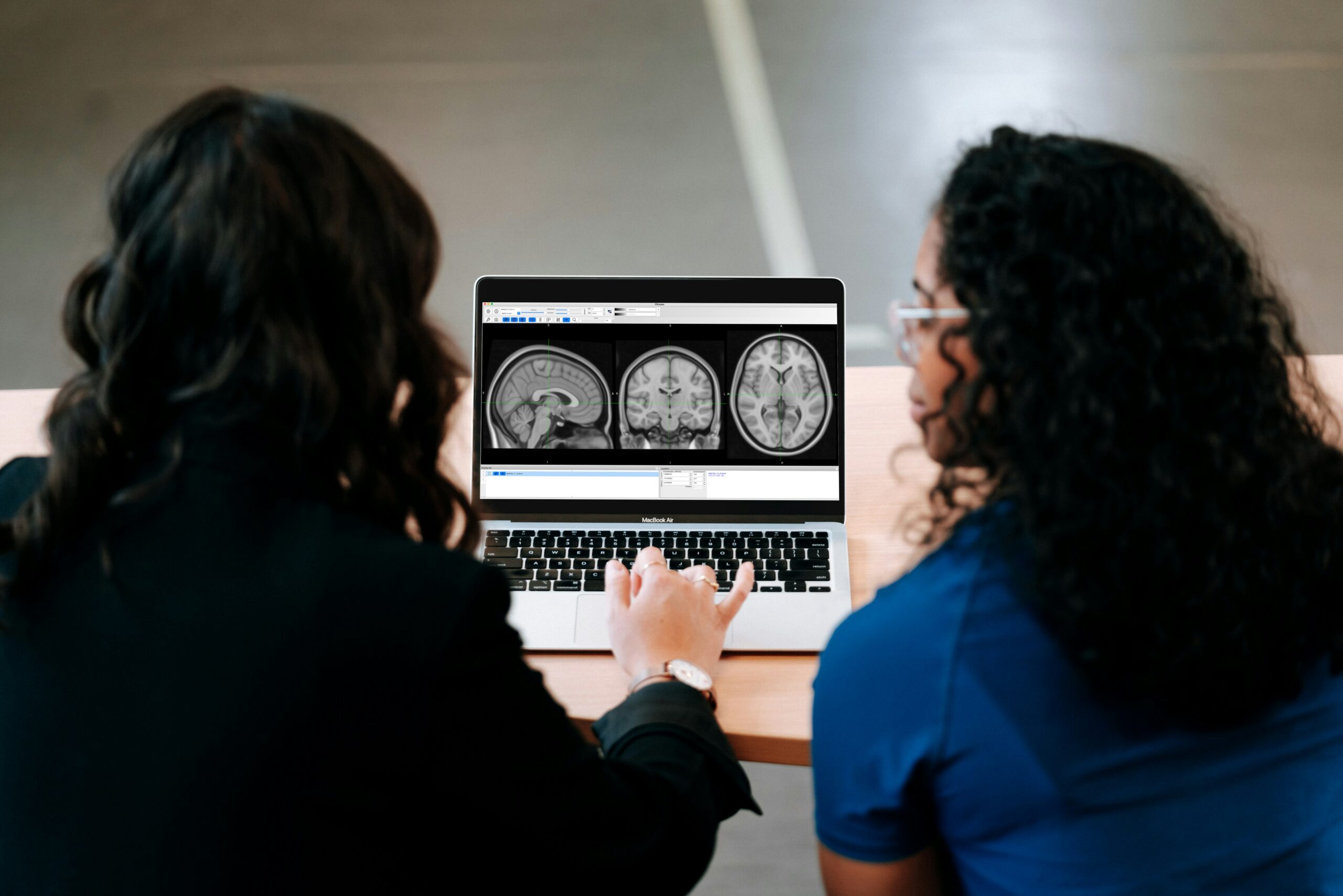 doctor and patient look at brain scan on laptop - traumatic brain injury lawyers
