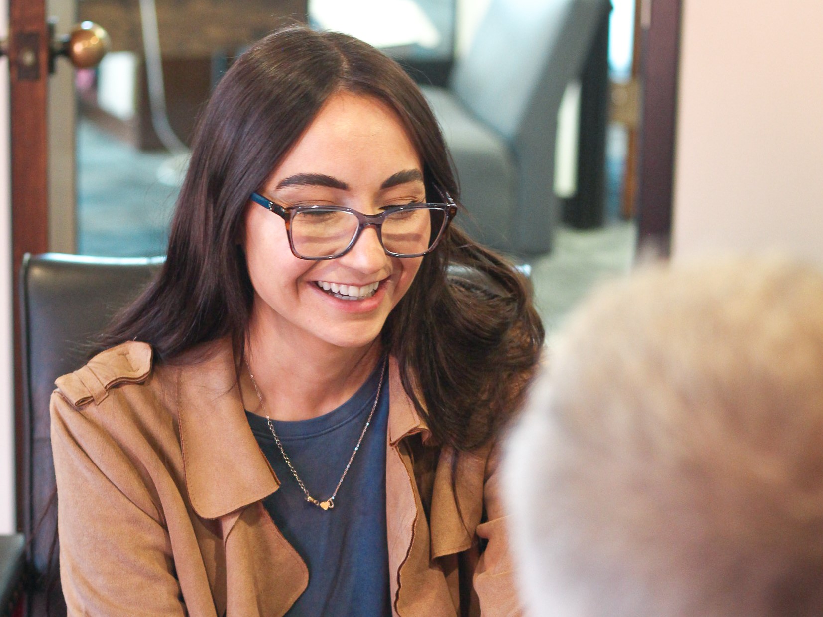 girl sits at desk smiling - traumatic brain injury lawyers