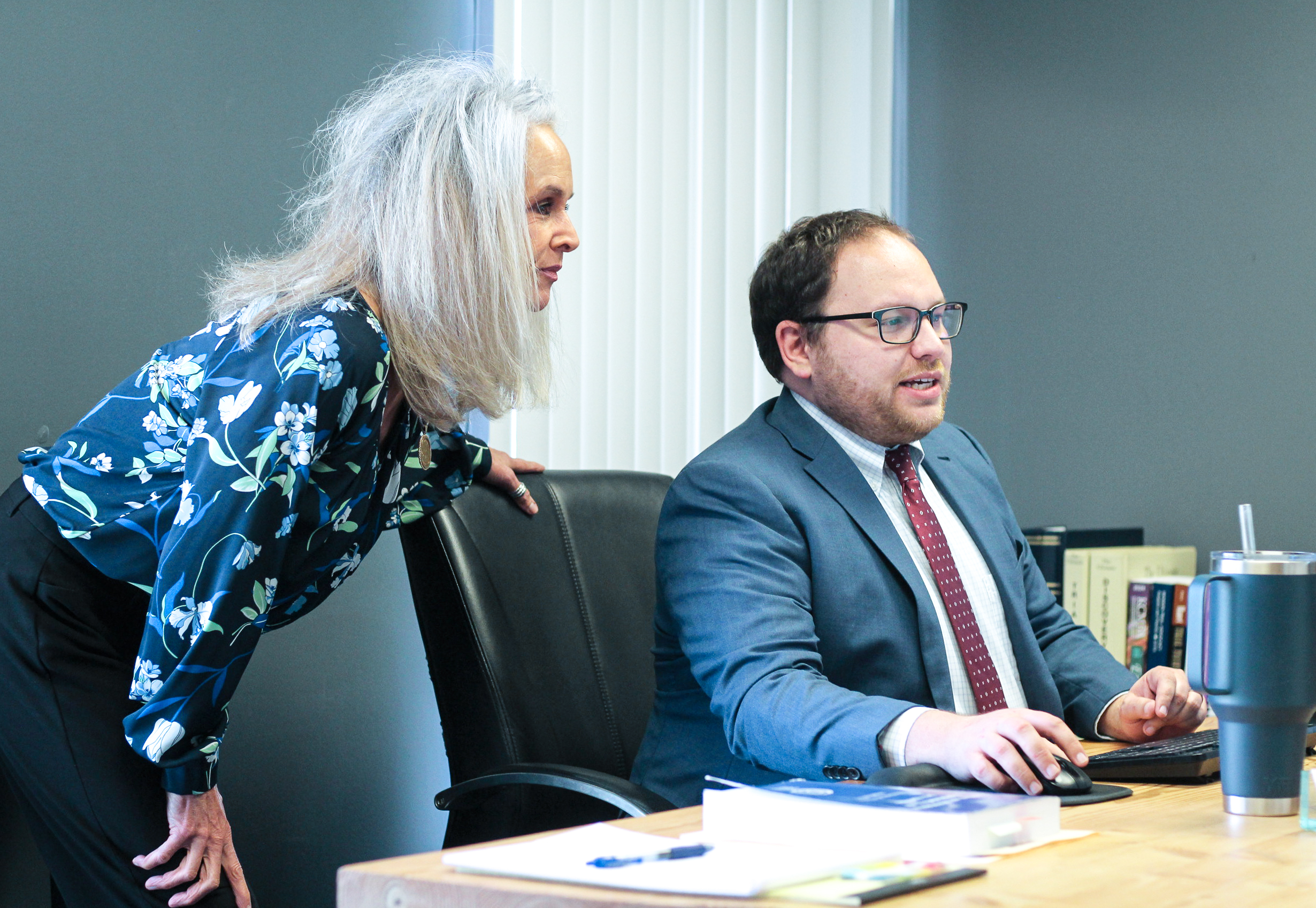 Kansas City pedestrian accident attorney studies compute screen with paralegal