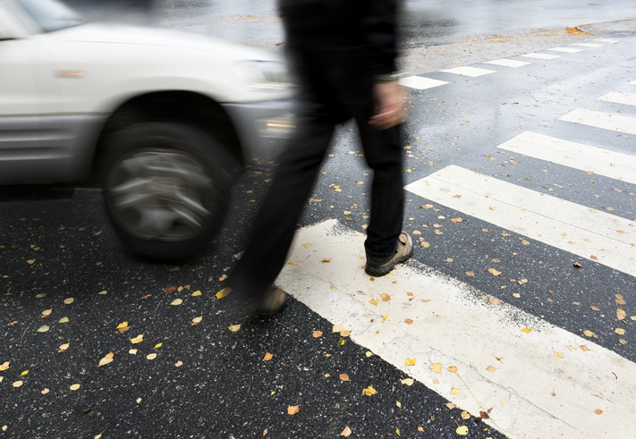 man on pedestrian crossing in danger of being hit by car - Kansas City pedestrian accident attorneys