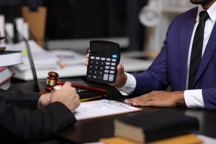 lawyer shows fee cost on calculator to client - topeka personal injury lawyers